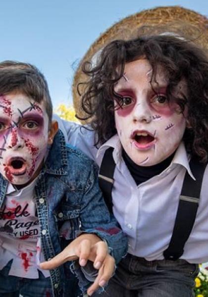 Enfants déguisés en zombies dans un parc à thème.