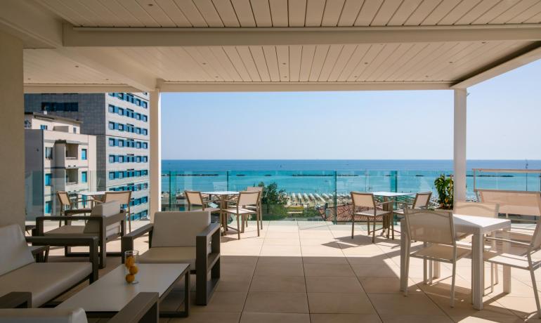 Terrace with sea view, modern furnishings, and clear sky.