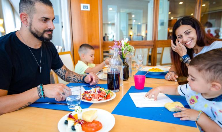 Family dining, smiles with diverse food.