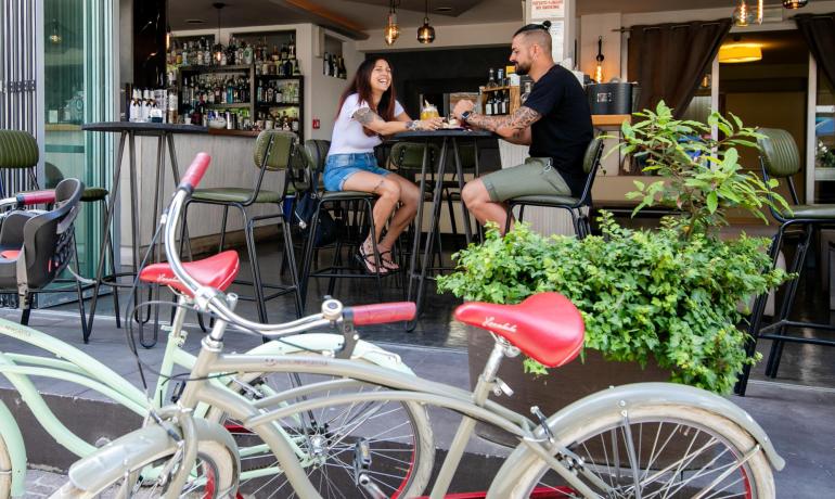 Couple smiles in a bar with bicycles in the foreground.