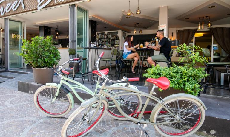 Couple at a bar with bikes parked outside.